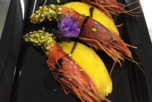 gambero rosso al croccante di pistacchio su frutto esotico e1678799942997